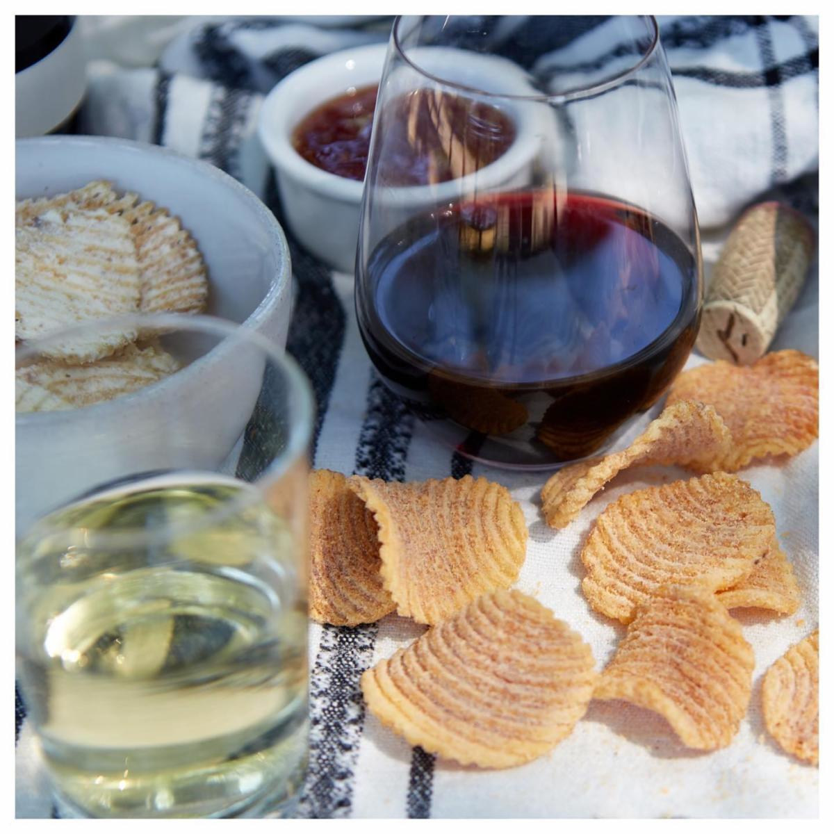 Glasses of red and white wine with chips